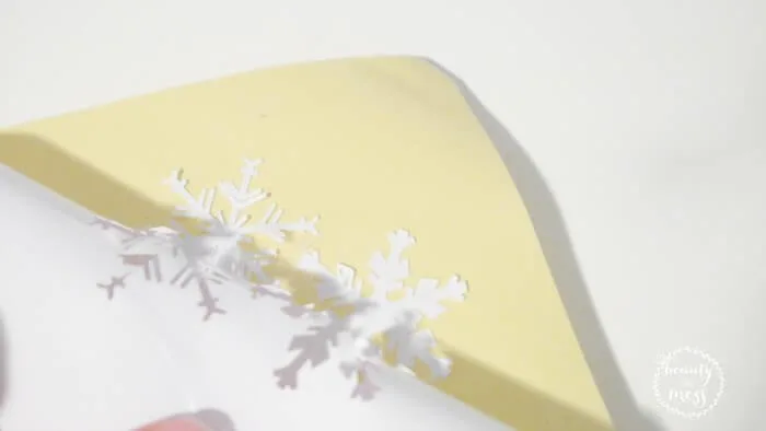 peeling snowflakes off adhesive paper