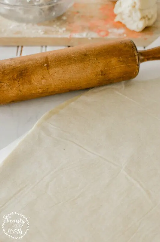 Roll the dough a little and then place another sheet of parchment paper on top (1)