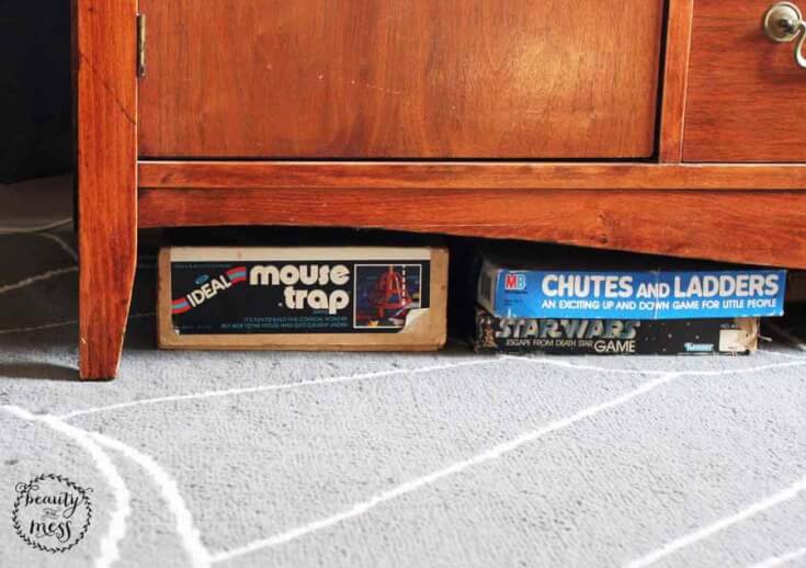 board games in boxes shown stored under a hutch