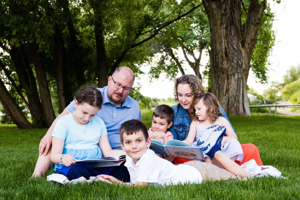 Beauty in the Mess Family Reading books on a blanket picnic