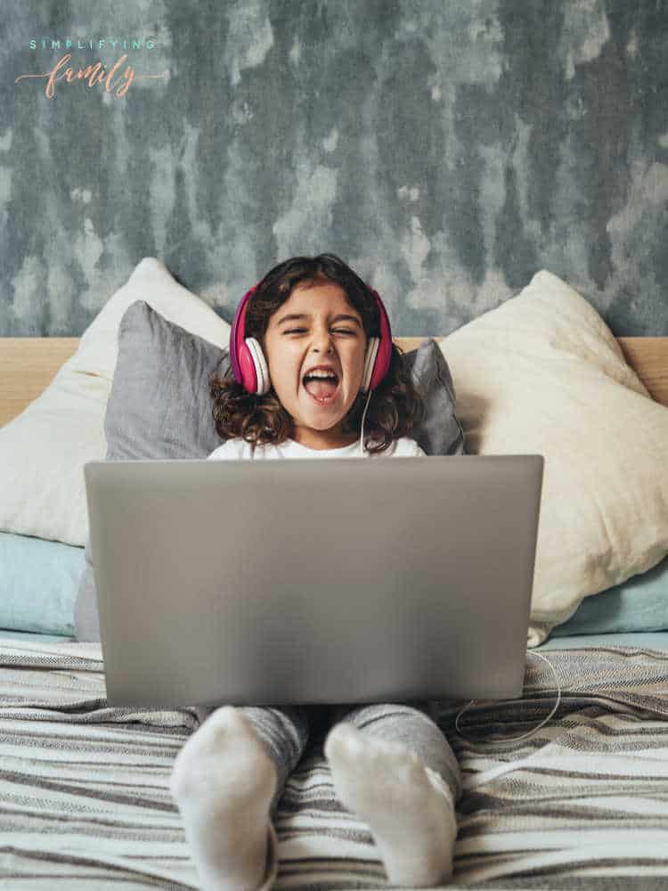fun activities for kids on zoom girl excited to be on laptop with headphones