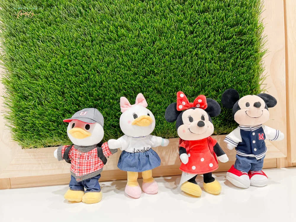 Disney's Mickey Mouse, Minnie Mouse, Donald Duck, and Daisy Duck Disney nuiMOs in front of grass wall with wood frame