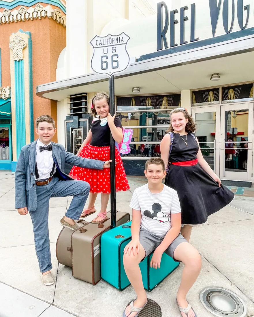 Hollywood Studios Sunset Blvd Route 66 sign with four children smiling disney vacation tips